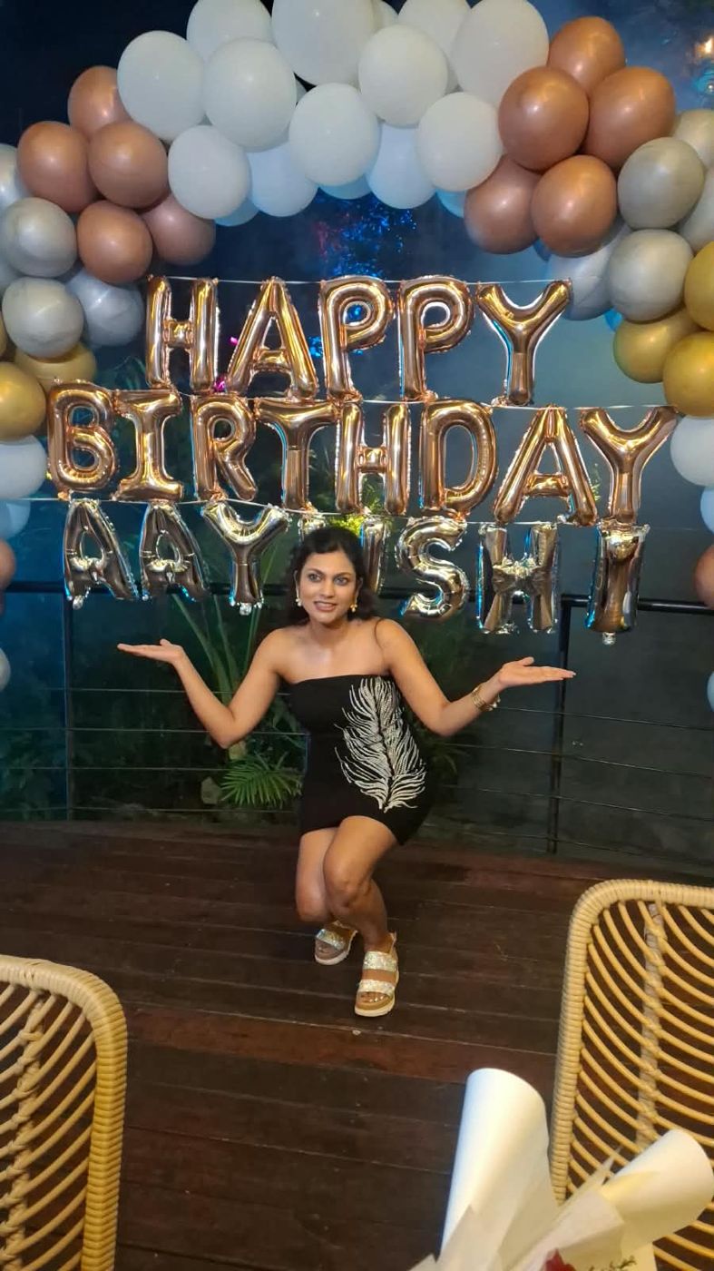 The birthday girl at the Happy Birthday arch